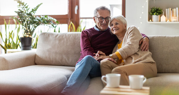 Eine Frau und ein Mann sitzen auf dem Sofa in ihrem Wohnzimmer. | © Adobe Stock